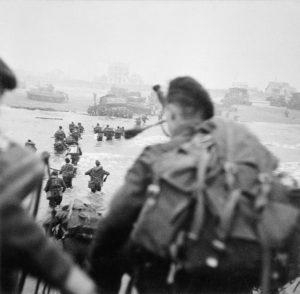  Piper Bill Millin est au premier plan, Lord Lovat, sur la droite dans la colonne, marchant dans l'eau.